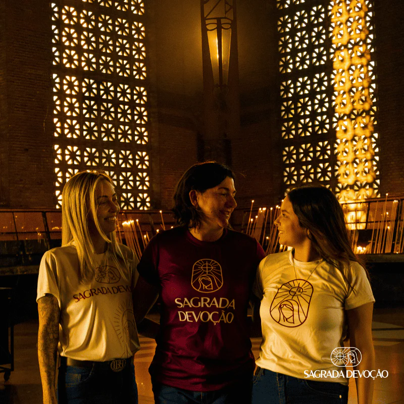 Três devotas sorrindo em ambiente religioso com arquitetura dourada